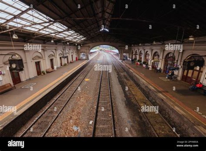 Outrage as boy lies with his head dangling over side of train station platform while an adult watches on