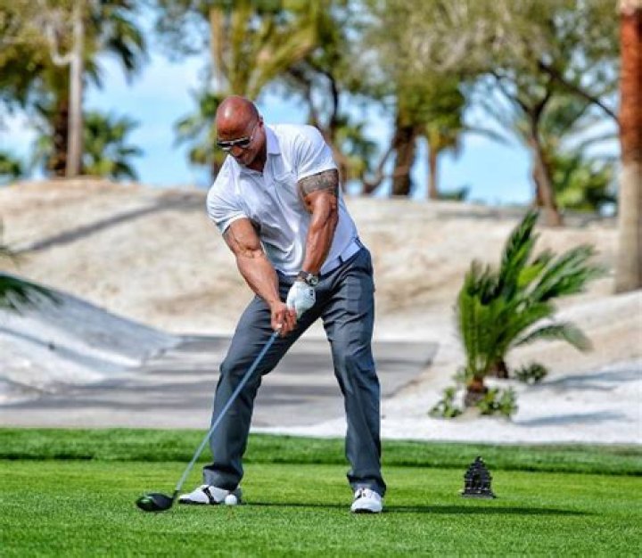 The Rock has muscles bulging out of his shirt as he vows to break the world long drive record